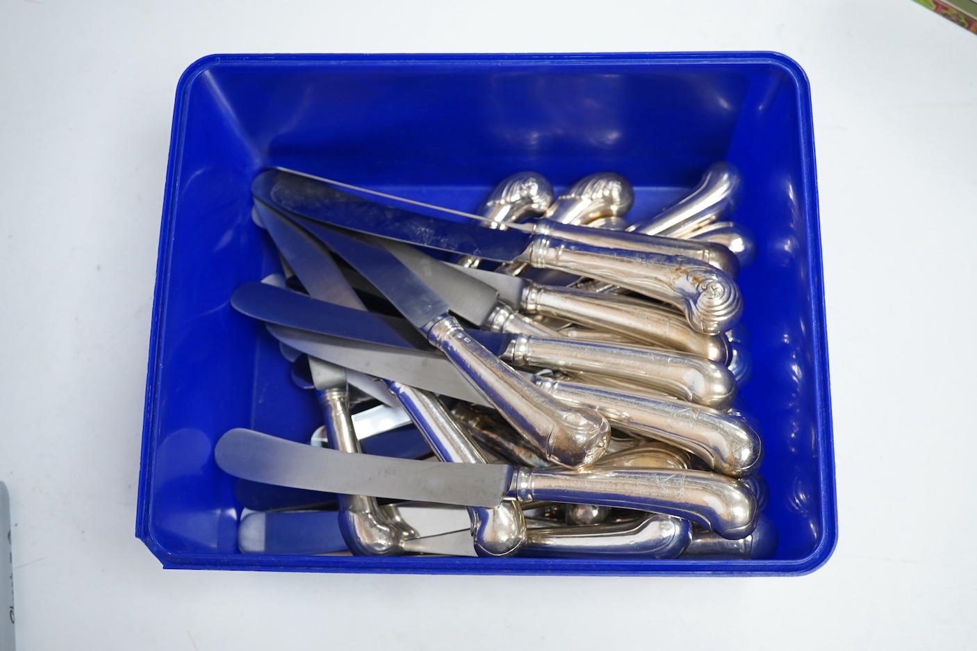 A set of twelve Georgian loaded silver pistol grip table knives, with scroll decorated handles (re-bladed), 23.5cm, together with twelve other assorted 19th century white metal or silver handled dessert knives and eight